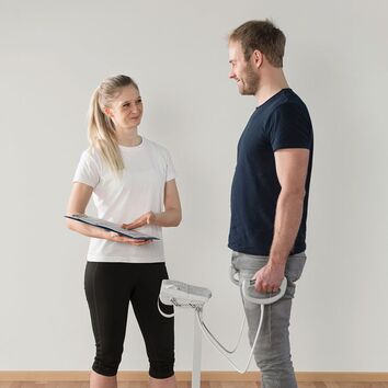 Mann steht auf einer Biawaage und wird von einer blonden Frau getestet